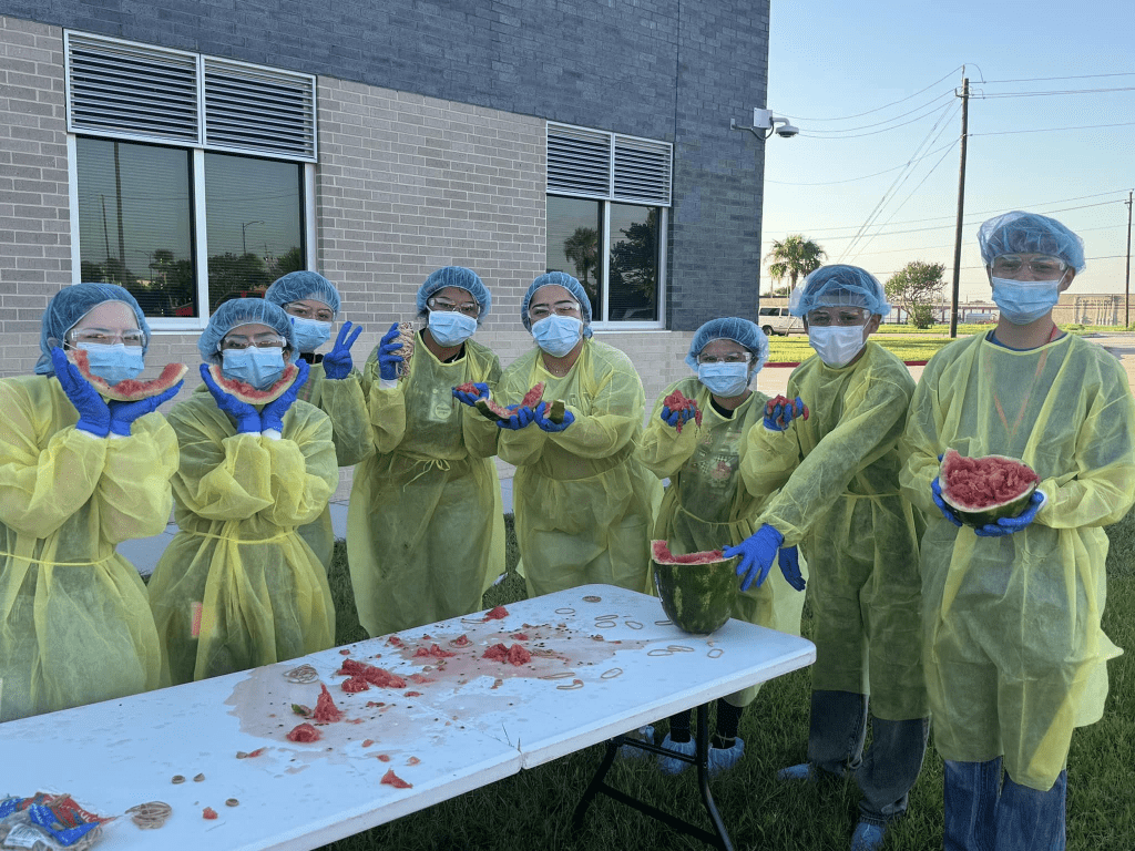 students posing with aftermath of watermelon explosion